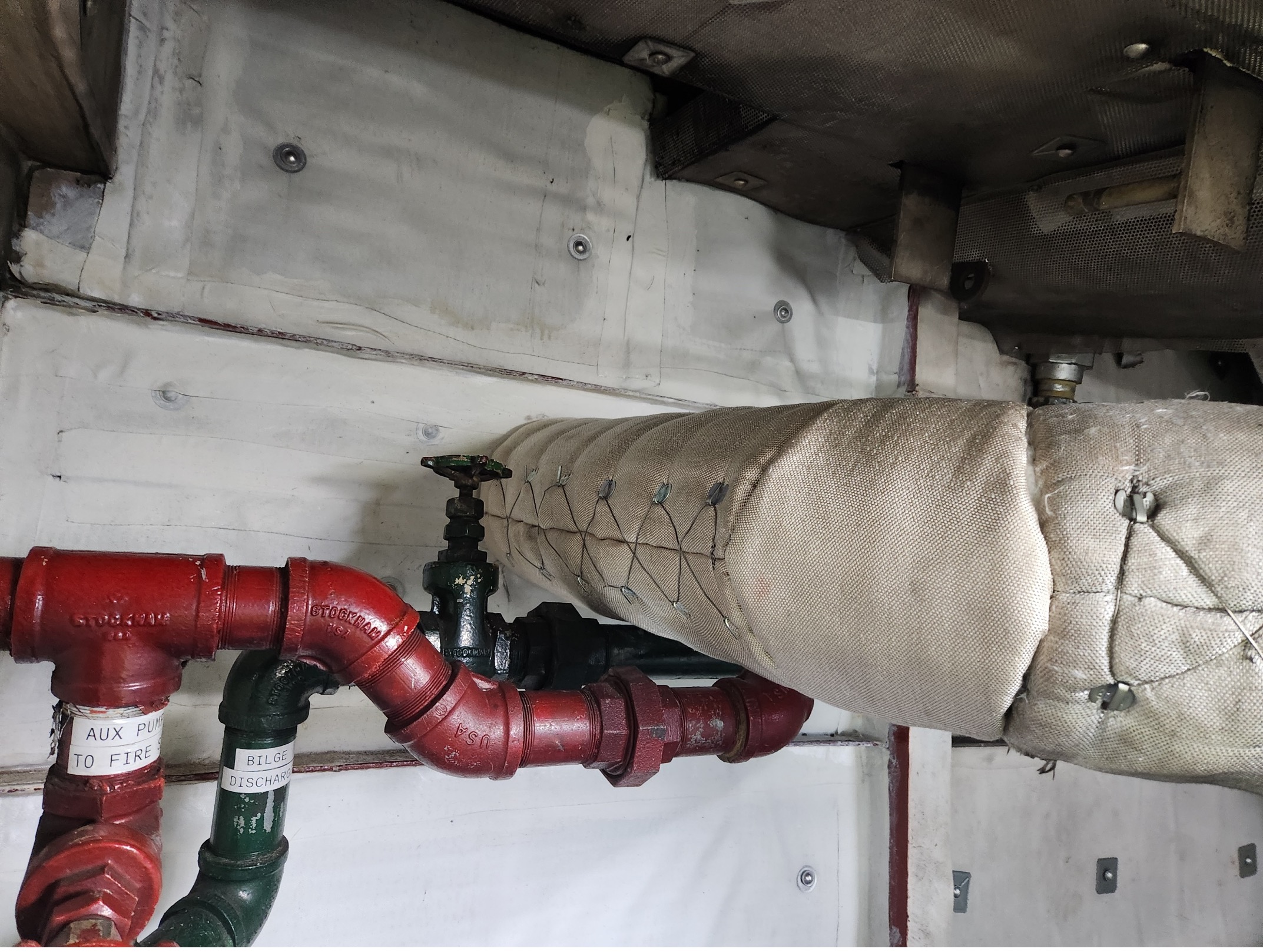 Custom removable insulation pads. These were constructed using heavy fiberglass cloth with a high temperature fiberglass mat core, then secured in place with stainless steel wire and lacing hooks. This improves both efficiency and safety by maintaining temperatures and preventing heat loss. Designed for easy removal and reinstallation, allowing for quick access during inspections and maintenance. (Different from the silicone coated pads, these do not offer weather resistant barriers however these are more commonly used)
